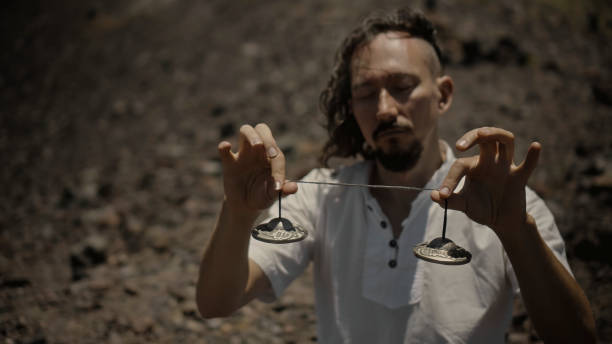 Asian guy playing Tibetan singing copper cups on a viewing mountain