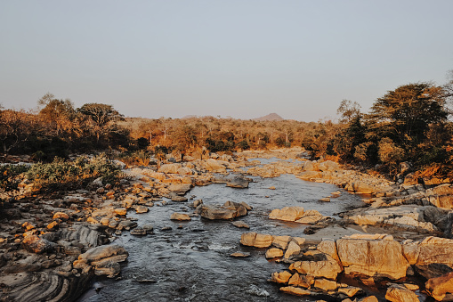 Sunlight shining over the rocks and boulders in the Mkulumadzi River.