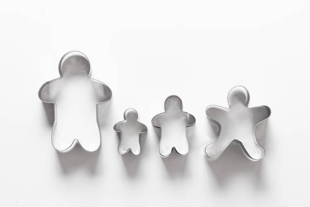 Christmas-themed cookie cutters in shape of gingerbread man isolated on white. Creative concept happy family.