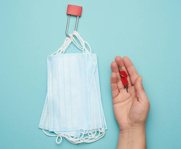 istock disposable mask and a metal lock on a blue background 1282867570