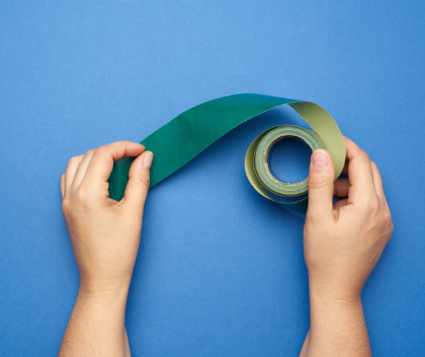 istock hand hold green rolled paper sticky tape 1282867737