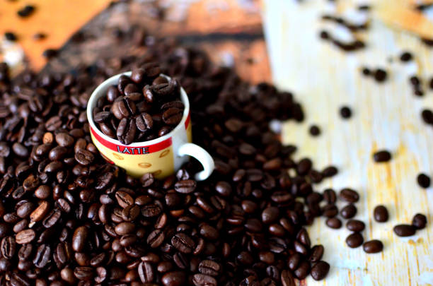 istock Coffee grains are poured into a small cup and spread around the table 1282868463