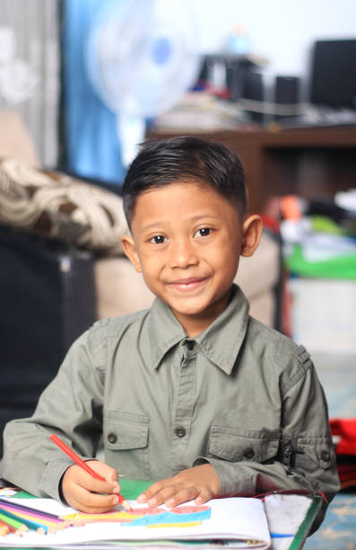 An elementary student showing the results of a craft, an assignment from school.