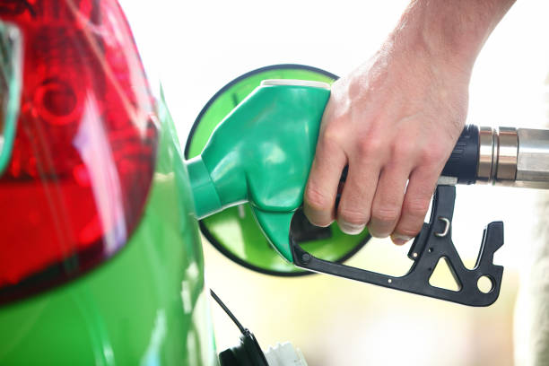tankstellenpumpe - tankbenzin oder biodiesel im grünen auto - ethanol stock-fotos und bilder