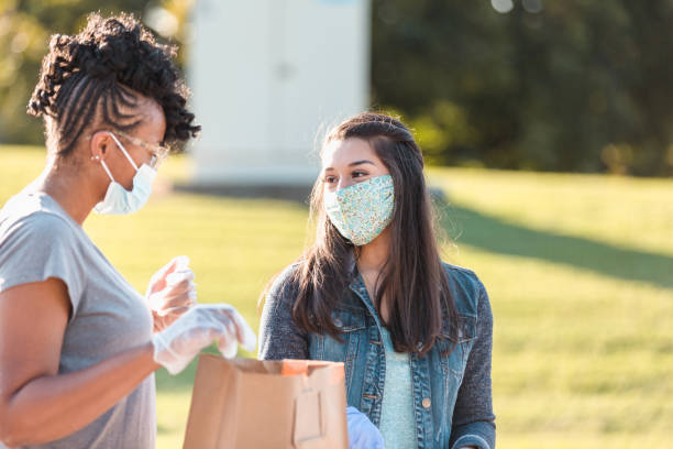 istock Female friends chat while working at food drive 1282871732
