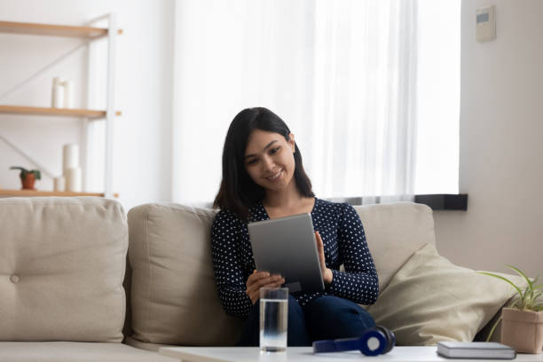 istock Smiling Asian girl relax on couch using tablet 1282871779
