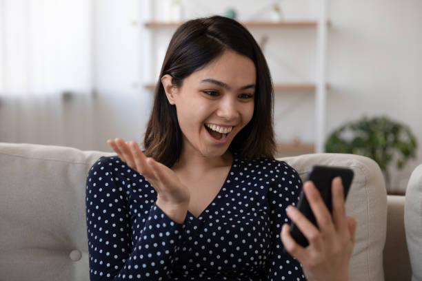 istock Overjoyed Asian woman triumph with message on cell 1282871793