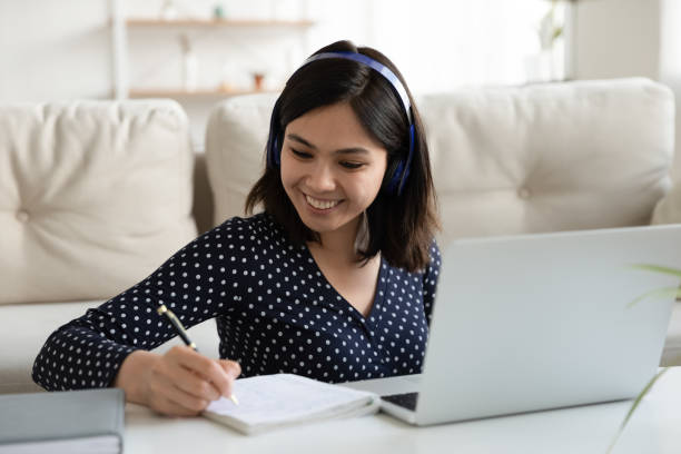 istock Smiling Asian female study online on laptop from home 1282871825
