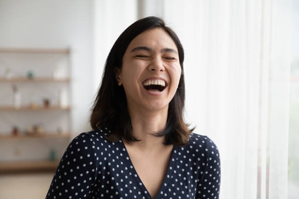 istock Overjoyed asian woman have fun laughing at joke 1282871829