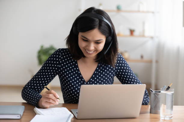 istock Smiling asian girl in headphones study distant on laptop 1282871875