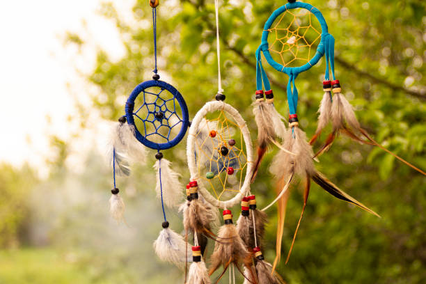 istock Dream catchers evolve in the wind, against a blurred green background of plants with copy space, symbol, tradition, signs. boho style 1282871949