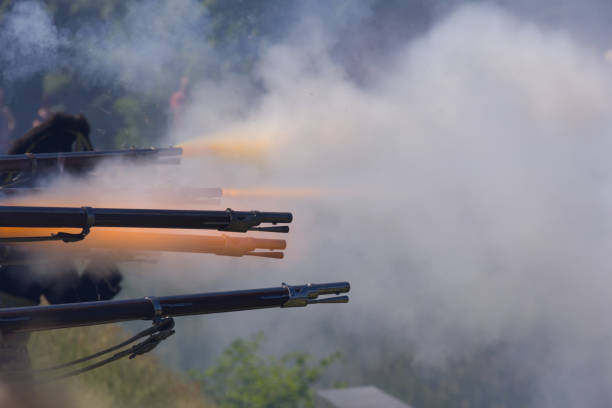 flintlock muzzle loader muskets guns firing. Smoke from the gunpowder fills the air. flintlock muzzle loader muskets guns firing. Smoke from the gunpowder fills the air. reenactment stock pictures, royalty-free photos & images