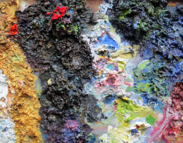 istock Congealed multi coloured oil paint on old discarded wooden pallet board 1282873556