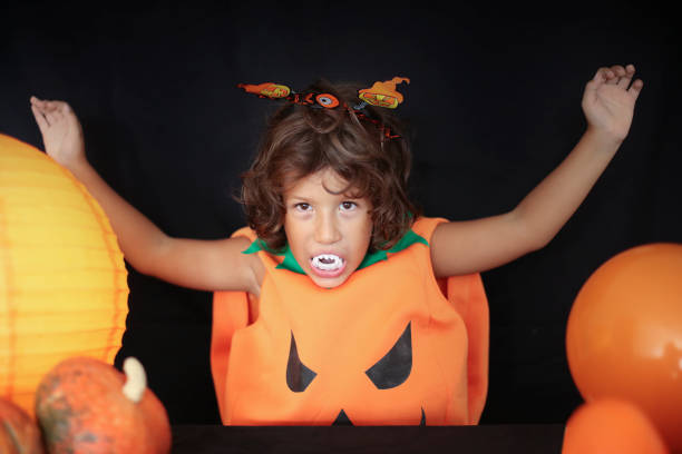 istock Cute kid in halloween costume scaring pose. 1282874619