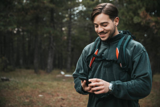 istock Man hiking with a backpack and holding hiking pole 1282874967