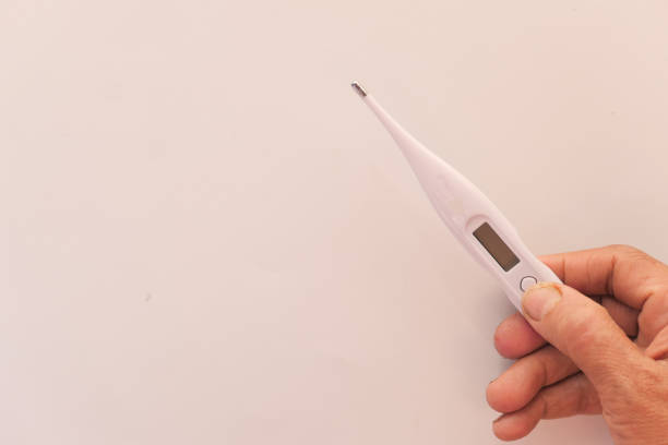 istock senior women hand holding digital thermometer, top view . 1282876101