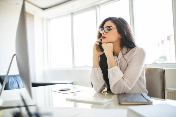 istock Serious woman using her smart phone and working in office 1282877815