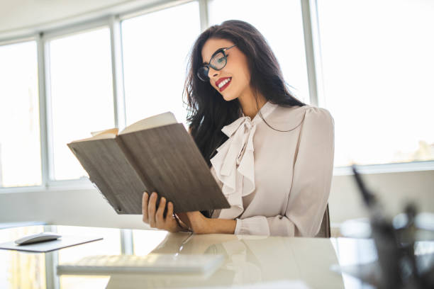 istock Young business woman reading diary, panning the day and working on computer in her office 1282877857