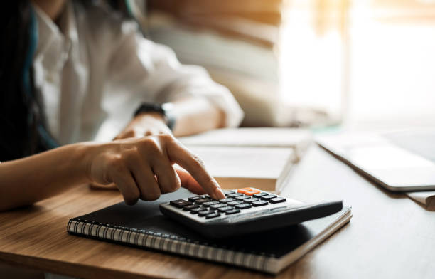 istock Young woman working with calculator at home. 1282878144