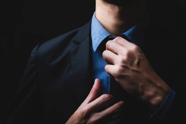 istock handsome confident businessman wearing and adjusting the black suit 1282880376