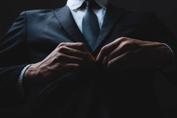 istock handsome confident businessman wearing and adjusting the black suit 1282880453