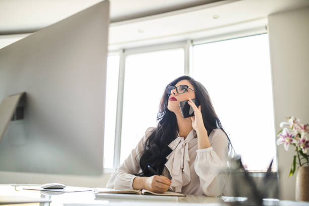 istock Tired woman using her smart phone and working in office 1282880469