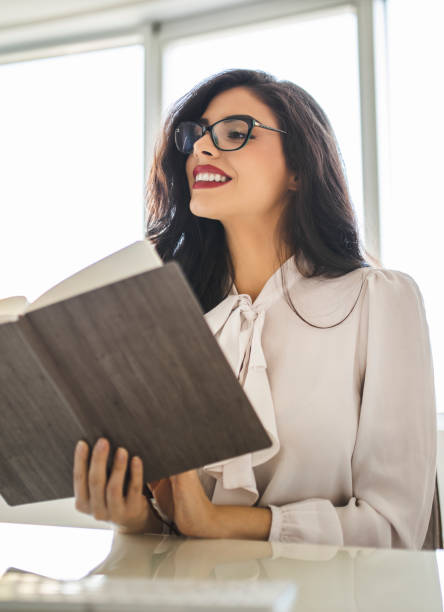 istock Young business woman reading diary, panning the day and working on computer in her office 1282880806