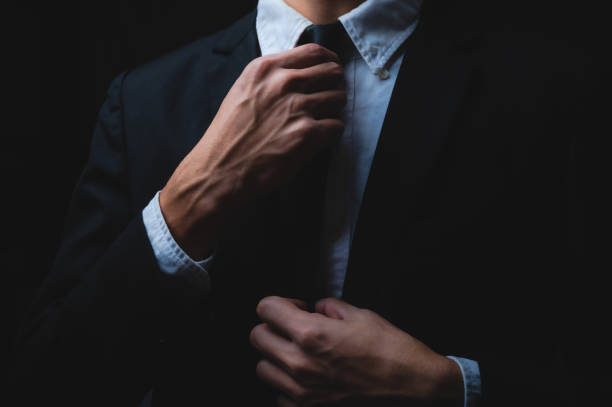 business man in black suit and adjusting his necktie