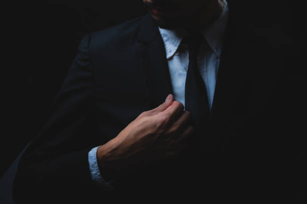 istock handsome confident businessman wearing and adjusting the black suit 1282881182