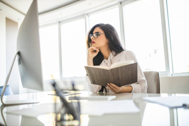 istock Serious woman working in her office, reading and checking documents 1282881505