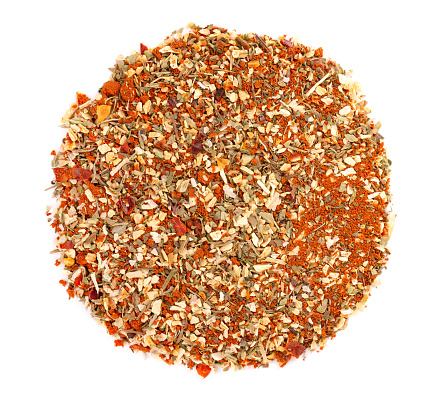 Mix of herbs, spices and dry tomatoes, isolated on white background. Natural organic food seasoning. Top view