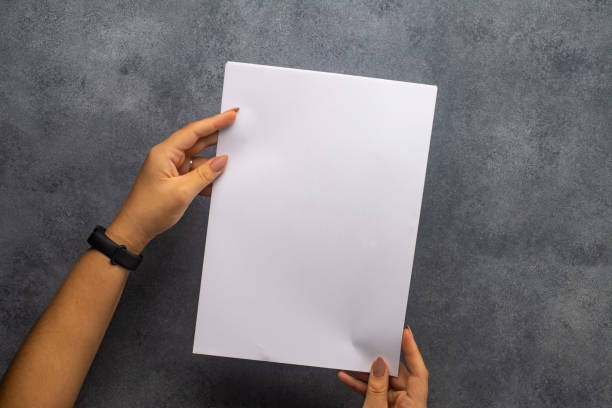 istock White sheet of paper in female hands. 1282881706