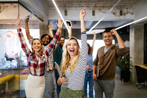 Group of successful business people in office celebrating profits and team building