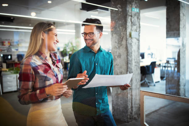 istock Colleagues discussing business and smiling while walking through the office corridor 1282881998