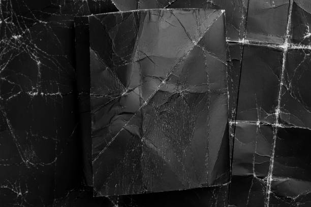 istock Black on black. Blank wrinkled paper rectangle on textured crumpled creased background 1282882187