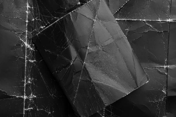 istock Black on black. Blank wrinkled paper rectangle on textured crumpled creased background 1282882869