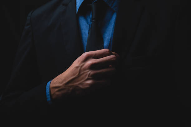 istock handsome confident businessman wearing and adjusting the black suit 1282883273