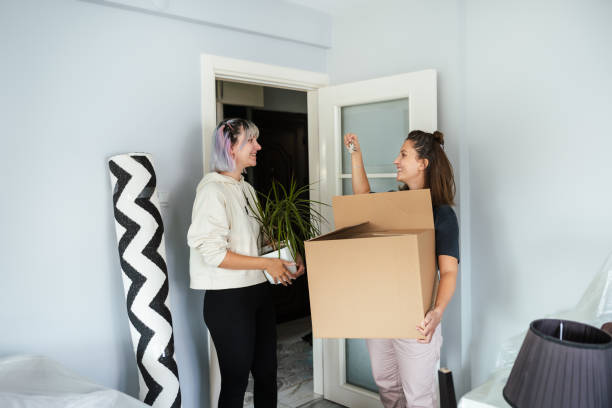 лучшие друзья празднуют переезд в свой новый дом - unpacking moving office container moving house стоковые фото и изображения