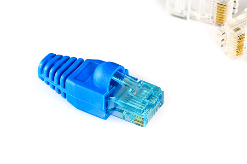 Blue RJ45 connector and blue boot for crimping rj-45 plugs for home Internet connection. Home network concept, macro close-up isolated on white background.