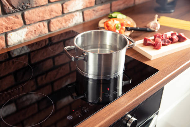 istock Metal pot stands on a modern induction cooker 1282891414