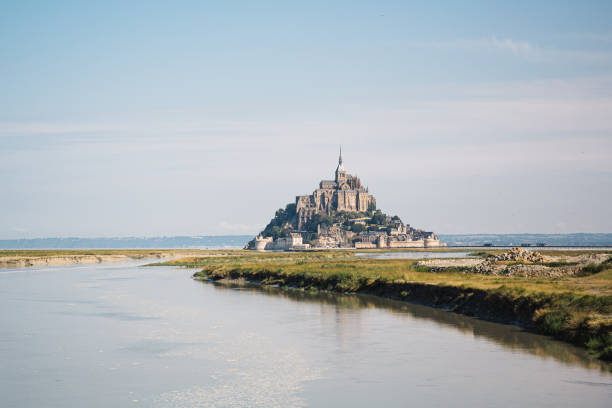 Mont Saint Michel view from the water in Normandy, France. Beautiful view of Mont Saint-Michel mont saint michel photos stock pictures, royalty-free photos & images