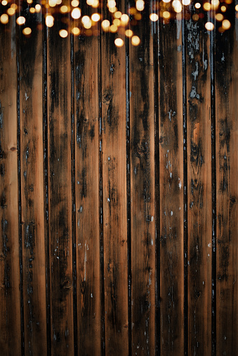 Shabby old board wall with golden bokeh lights.Vertical background for your dekorations concepts with space for text.