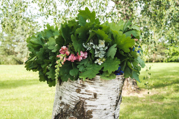 summer solstice wreath of oak branches and flowers on a birch block