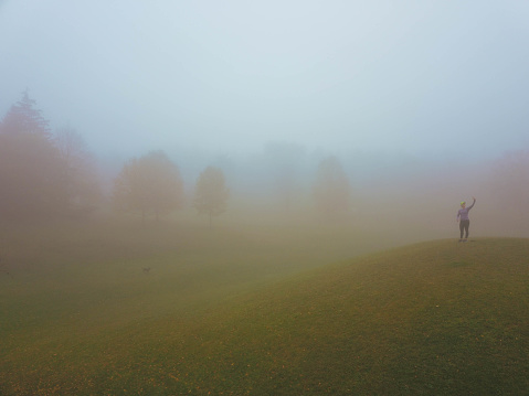 Woman taking pictures in a foggy morning