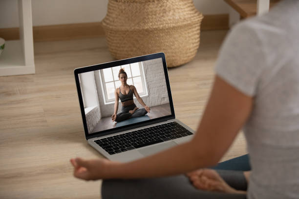 la donna pratica yoga guardando lezioni online al computer - yoga meeting foto e immagini stock