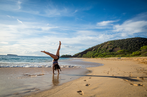 Teenage girl playing at tropical beach, Hawaii.