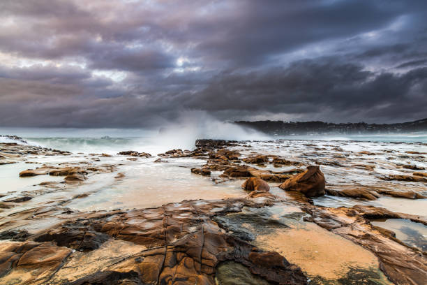 istock Rock platform, cascades and splashes with rain clouds by the seaside 1282897375