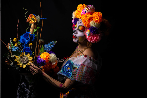 Woman personified as catrina for the day of the dead festival with flowers