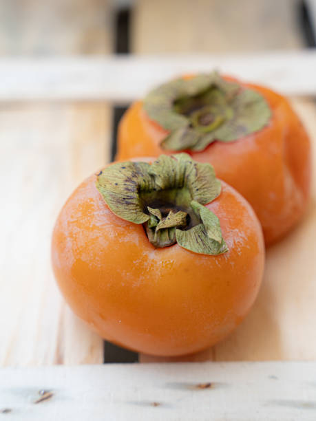 persimmons dans la boîte en bois - food wood vibrant color close up photos et images de collection