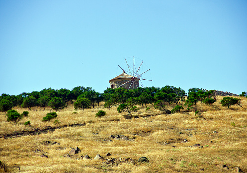 A horizontal shot of two white mills in an empty field in Belmonte, Spain